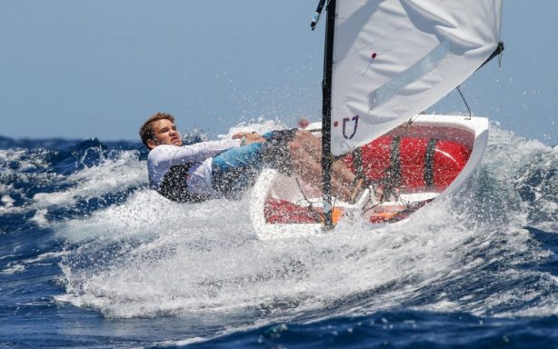 Un homme en train de faire de la planche à voile sur une mer agitée.